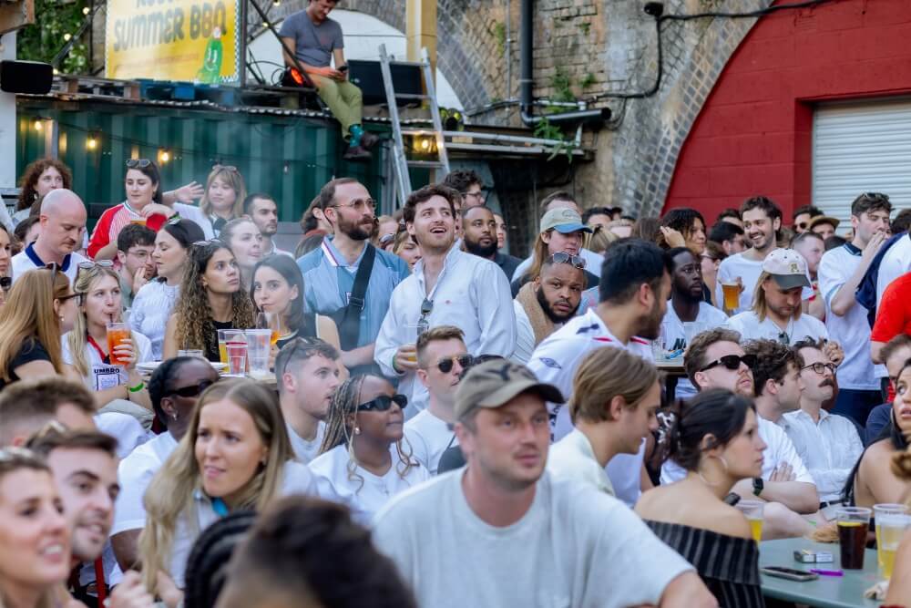 A crowd stand in a queue at the Peckham Arches bar